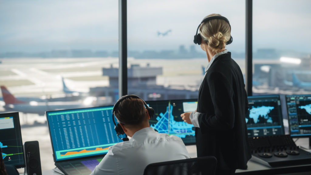 photo of two people in air traffic control tower directing traffic